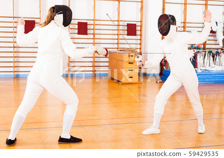 female athletes practicing movements at fencing battle 59429535