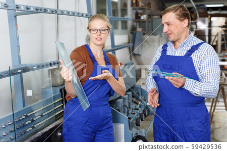 Glad woman and her male colleague busy working 59429536