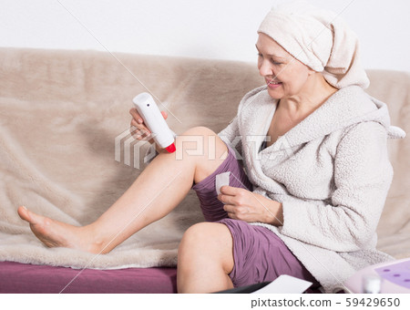 Woman doing body hair removal 59429650