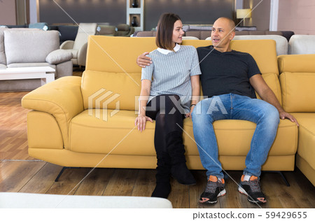 Couple sitting and testing new sofa Couple sitting and testing new sofa 59429655