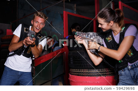 Young guy holding colored laser guns and took aim during laser tag game 59429698