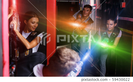 Group of young people playing laser tag game with laser guns 59430022