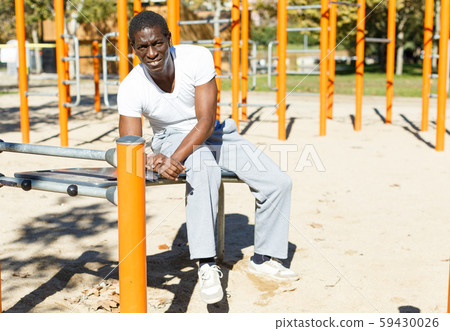 Young male posing before training at chin-up bar in park outdoor 59430026