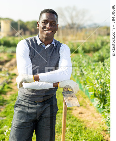 Smiling male with hoe Smiling male with hoe 59430096