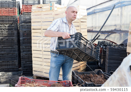 Farmer with organic fertilizer box 59430115