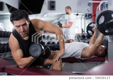 Man exercising with dumbbells in gym Man exercising with dumbbells in gym 59430117