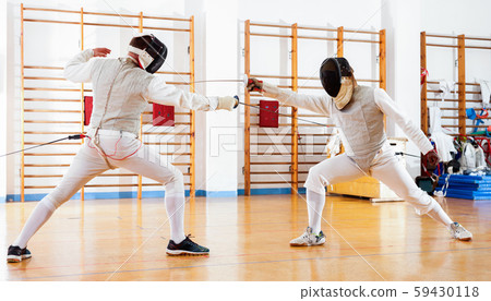 Portrait of athletes at fencing workout, practicing attack movements in duel Portrait of athletes at fencing workout, practicing attack movements in duel 59430118