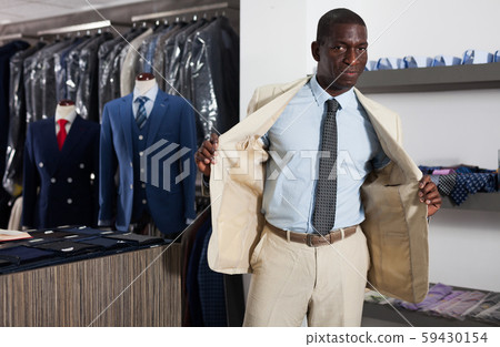 Afro-american man choosing casual jacket in fashion store 59430154