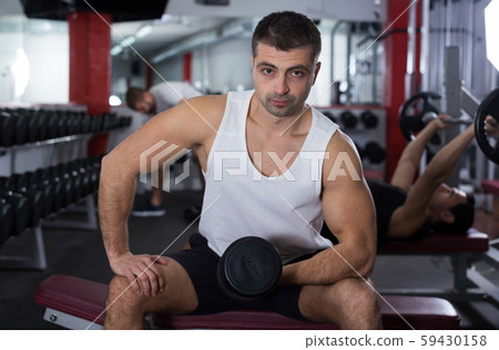 Man doing exercises with dumbbells at gym Man doing exercises with dumbbells at gym 59430158