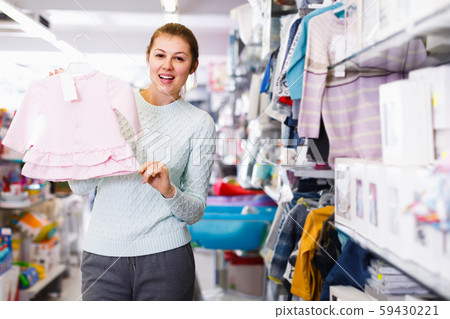cheerful pregnant woman is buying clothes for baby in thestore cheerful pregnant woman is buying clothes for baby in thestore 59430221