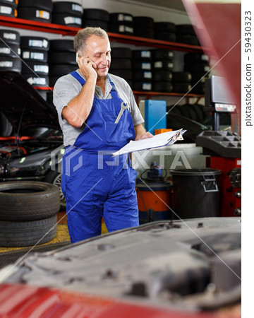Mechanic talking on phone 59430323