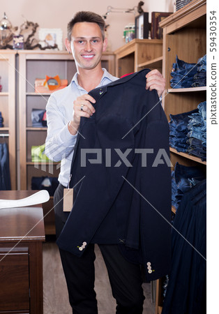 Smiling guy choosing new suit in male store 59430354