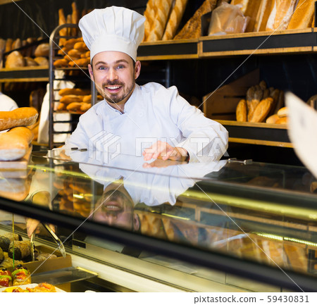 Young baker showing assortment of bakery Young baker showing assortment of bakery 59430831