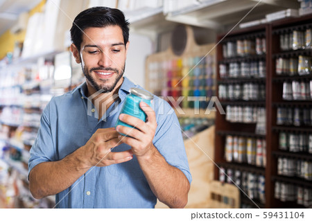Man choosing paints in store 59431104