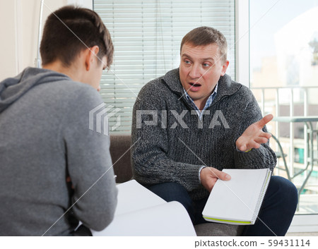 Father scolding son for poor school assignment Father scolding son for poor school assignment 59431114