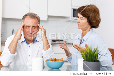 Unhappy mature couple discussion while quarrel in home interior Unhappy mature couple discussion while quarrel in home interior 59431186