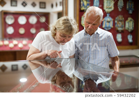 Couple looking at stands with exhibits 59432202