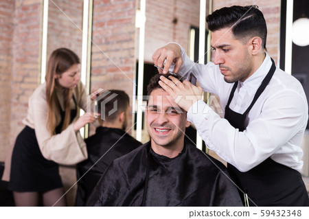 Hairdresser man doing styling of guy Hairdresser man doing styling of guy 59432348