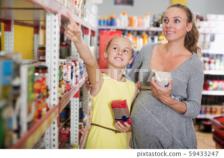 Happy girl with mother is choosing fresh goods 59433247