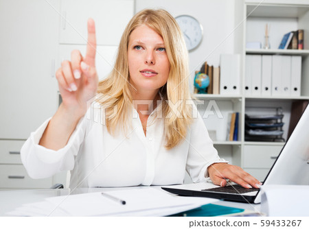 Confident businesswoman pointing to invisible screen Confident businesswoman pointing to invisible screen 59433267