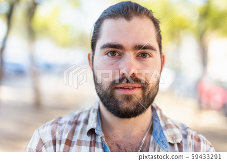 Portrait of an attractive man standing on street in a plaid shirt Portrait of an attractive man standing on street in a plaid shirt 59433291