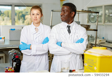 Experienced male and female scientists standing in laboratory Experienced male and female scientists standing in laboratory 59433294
