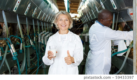 Woman with glass of milk on farm Woman with glass of milk on farm 59433397