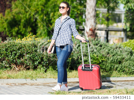 Girl walking around city with suitcase Girl walking around city with suitcase 59433411
