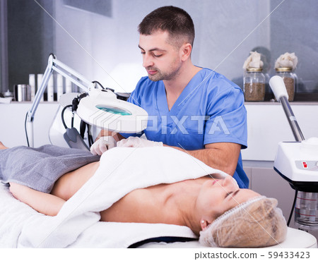 cosmetologist examining female body before procedure cosmetologist examining female body before procedure 59433423