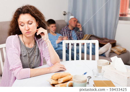Upset woman on background with relaxed husband and son Upset woman on background with relaxed husband and son 59433425