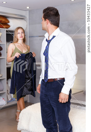 Man in bedroom and woman with his jacket Man in bedroom and woman with his jacket 59433427