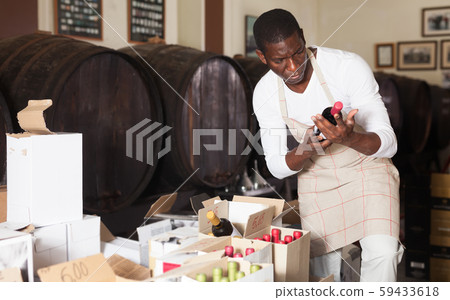 Winemaker inspecting wine bottles in store Winemaker inspecting wine bottles in store 59433618