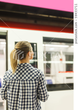 Back view of young woman waiting for train Back view of young woman waiting for train 59433711