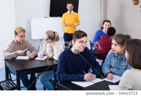 Female and male students 13-16 years old are having group exercises 59433723