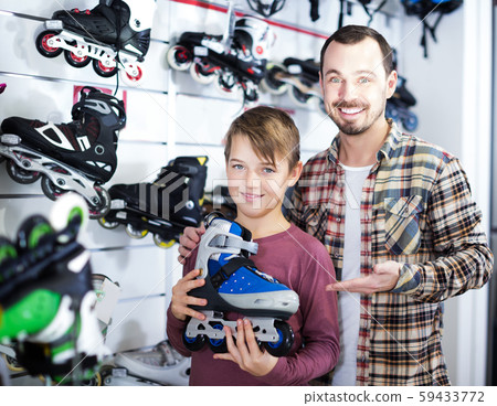 Seller assisting boy in choosing roller-skates Seller assisting boy in choosing roller-skates 59433772