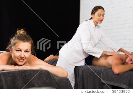 Portrait of couple getting relaxing massage in spa salon Portrait of couple getting relaxing massage in spa salon 59433993