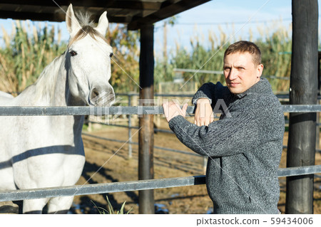Cheerful man horse farm worker 59434006