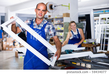 Portrait of experienced male worker with plastic window frame Portrait of experienced male worker with plastic window frame 59434077