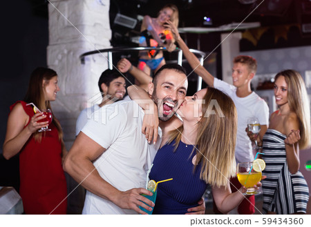 couple of smiling people together in the night club with drinks couple of smiling people together in the night club with drinks 59434360