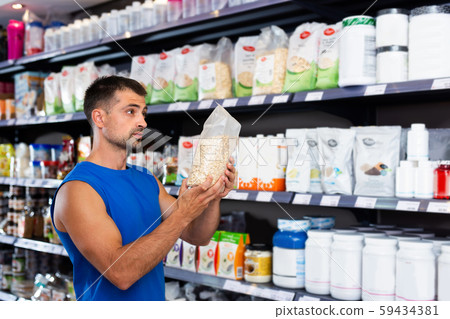 Man choosing food supplements in store 59434381