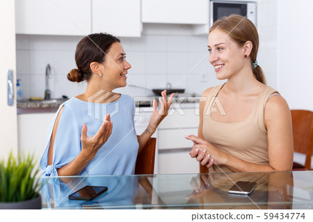 Two friendly girls having emotional conversation Two friendly girls having emotional conversation 59434774