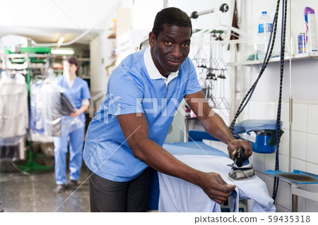 Man ironing clothes Man ironing clothes 59435318