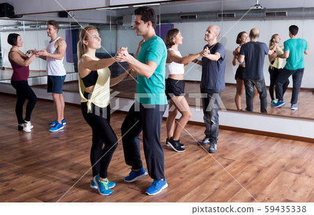 Group of smiling people dancing bachata together Group of smiling people dancing bachata together 59435338