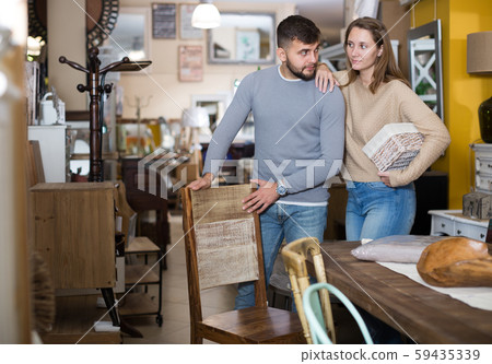 Couple looking for wooden chairs in shop Couple looking for wooden chairs in shop 59435339