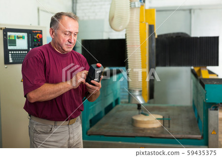 Elderly master manages 3d machine in factory Elderly master manages 3d machine in factory 59435375