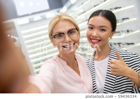 Appealing woman wearing glasses taking selfies in optical store 59436334