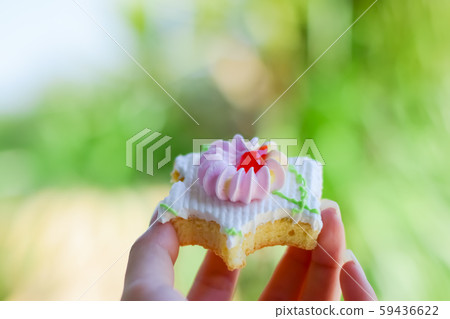 woman's hand holding cupcake topping with cream on 59436622