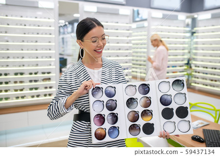 Young stylish girl showing the assortment of optical store 59437134