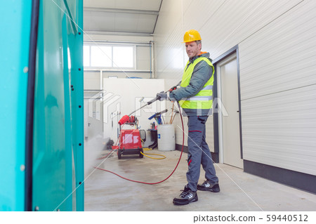 Worker cleaning a rental or mobile toilet 59440512