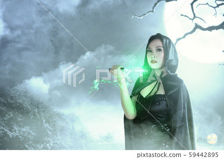 Asian witch woman in black hooded doing ritual magic with a knife Asian witch woman in black hooded doing ritual magic with a knife 59442895